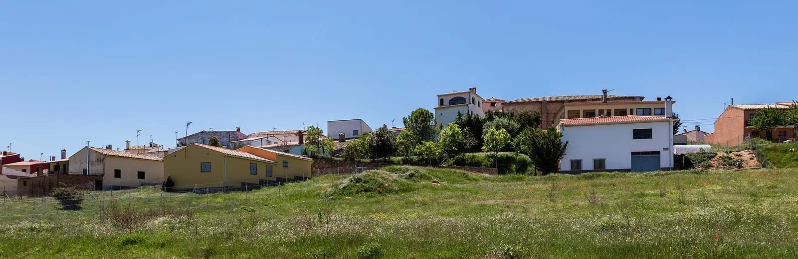 Casas de Arcos de la Sierra entre campos y montes