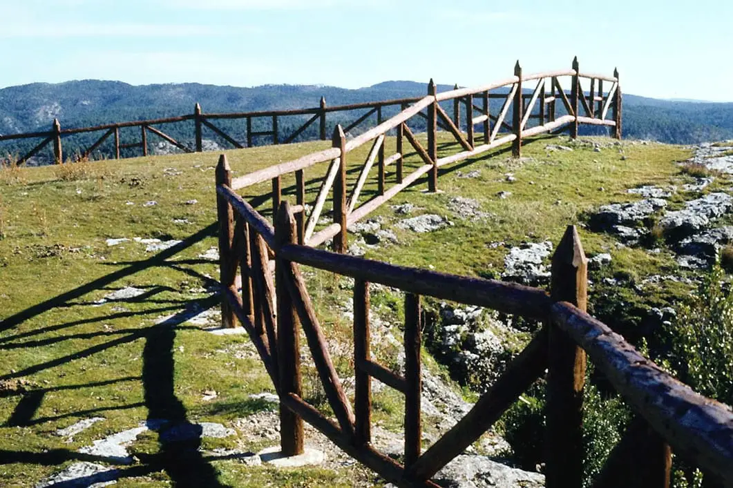 Barandilla de un mirador entre árboles en el Hosquillo