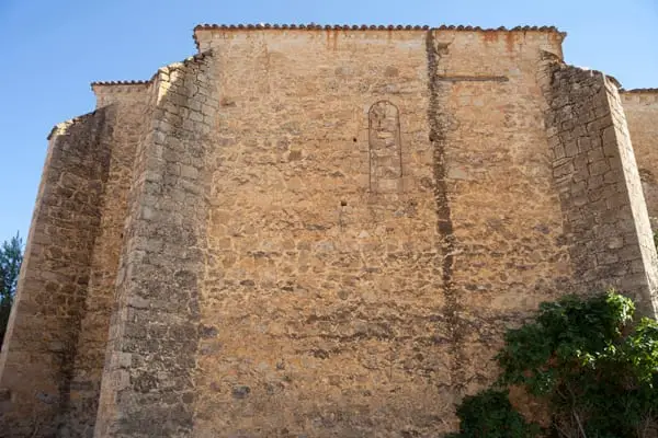 Ábside de piedra con contrafuertes de la iglesia panteón de Carboneras de Guadazaón