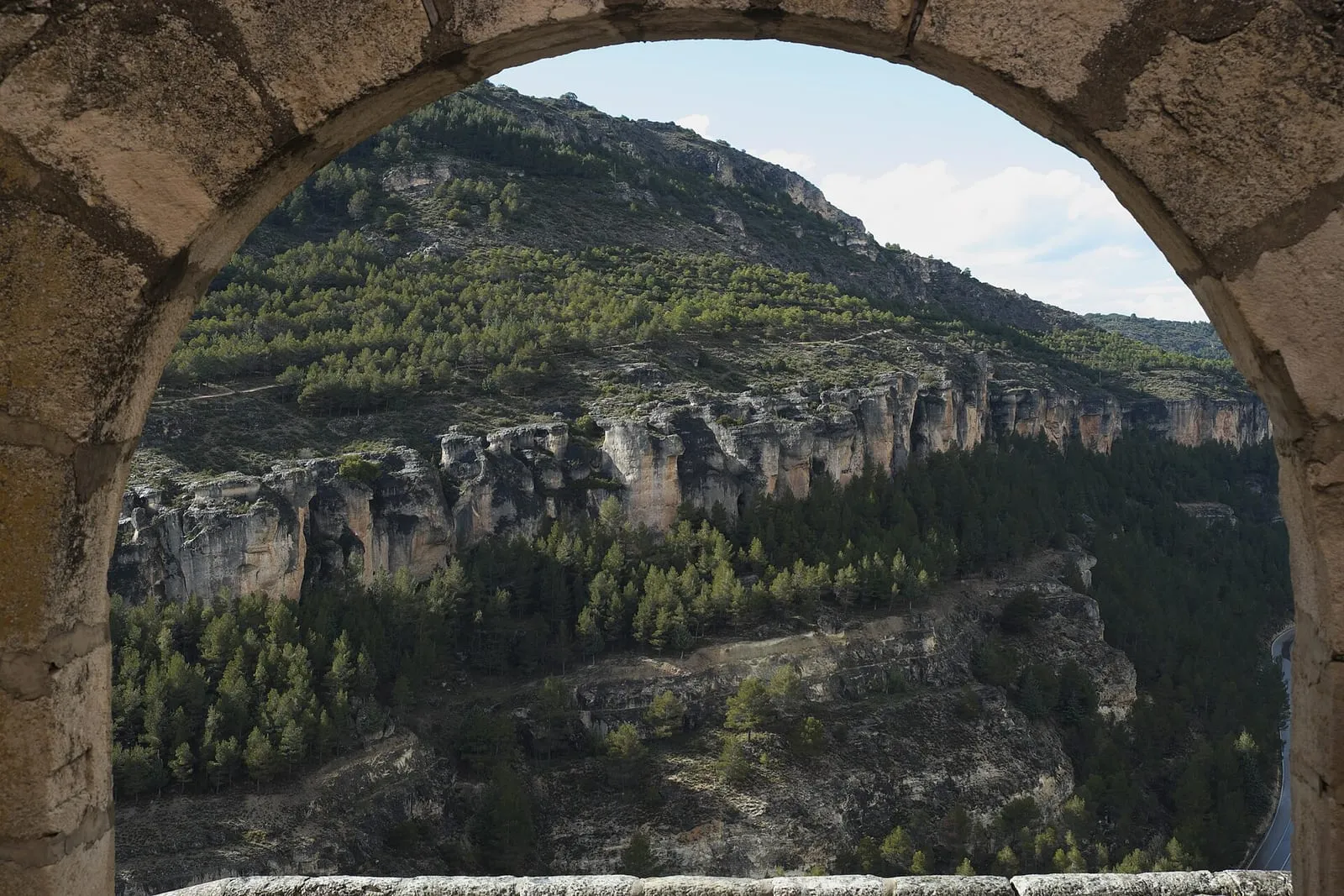 Hoz del Júcar y pinares vistos a través de un arco de piedra