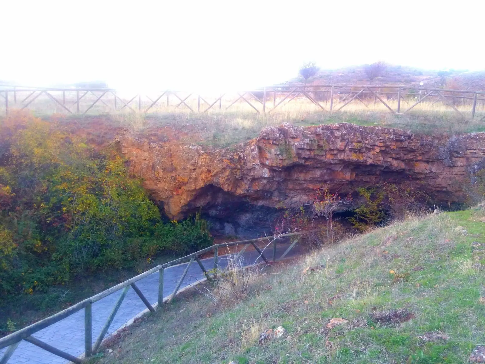 Escalera y boca de la mina de Cueva del Hierro entre rocas