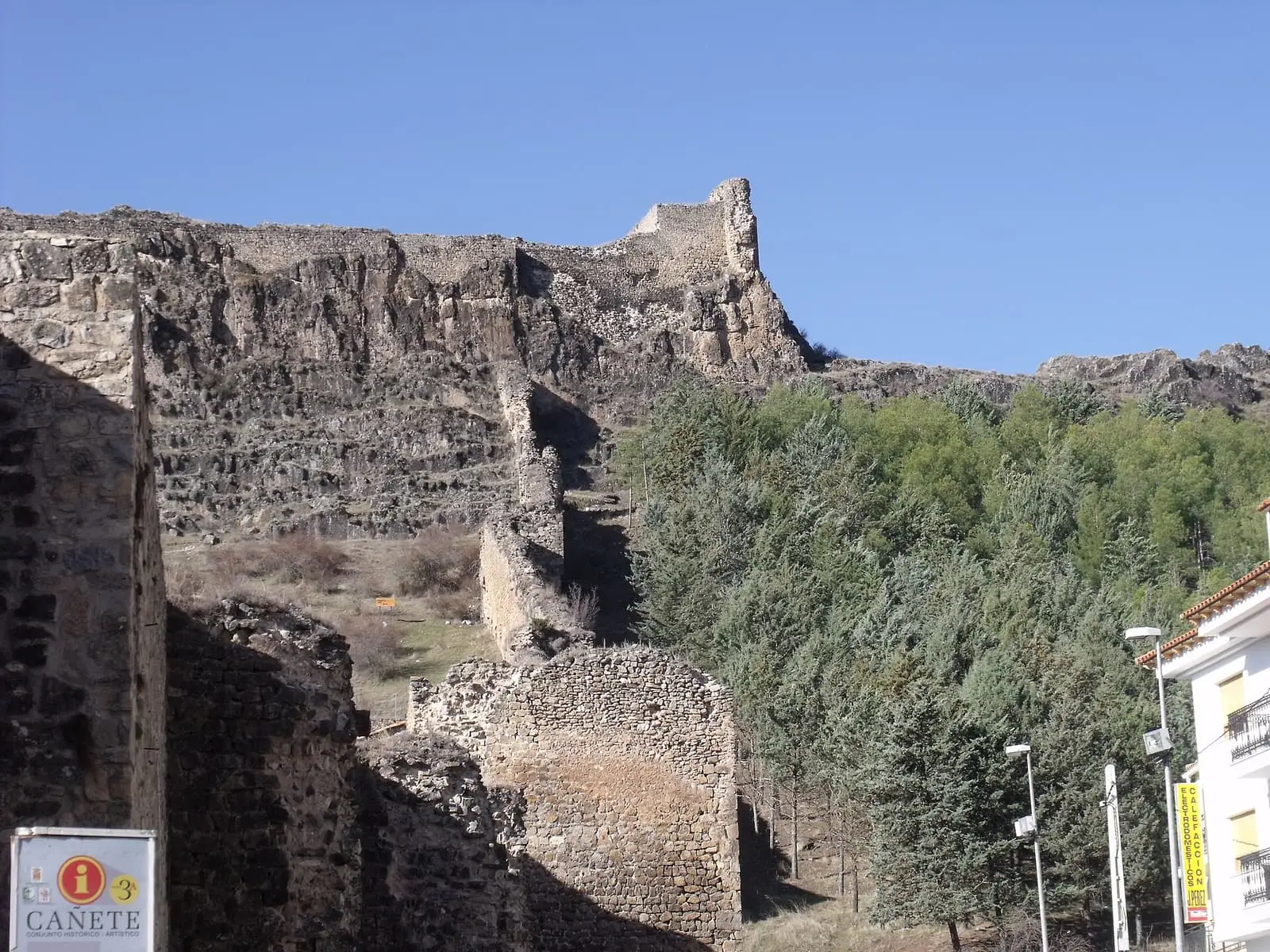 Muros y torreones de Cañete junto a una ladera